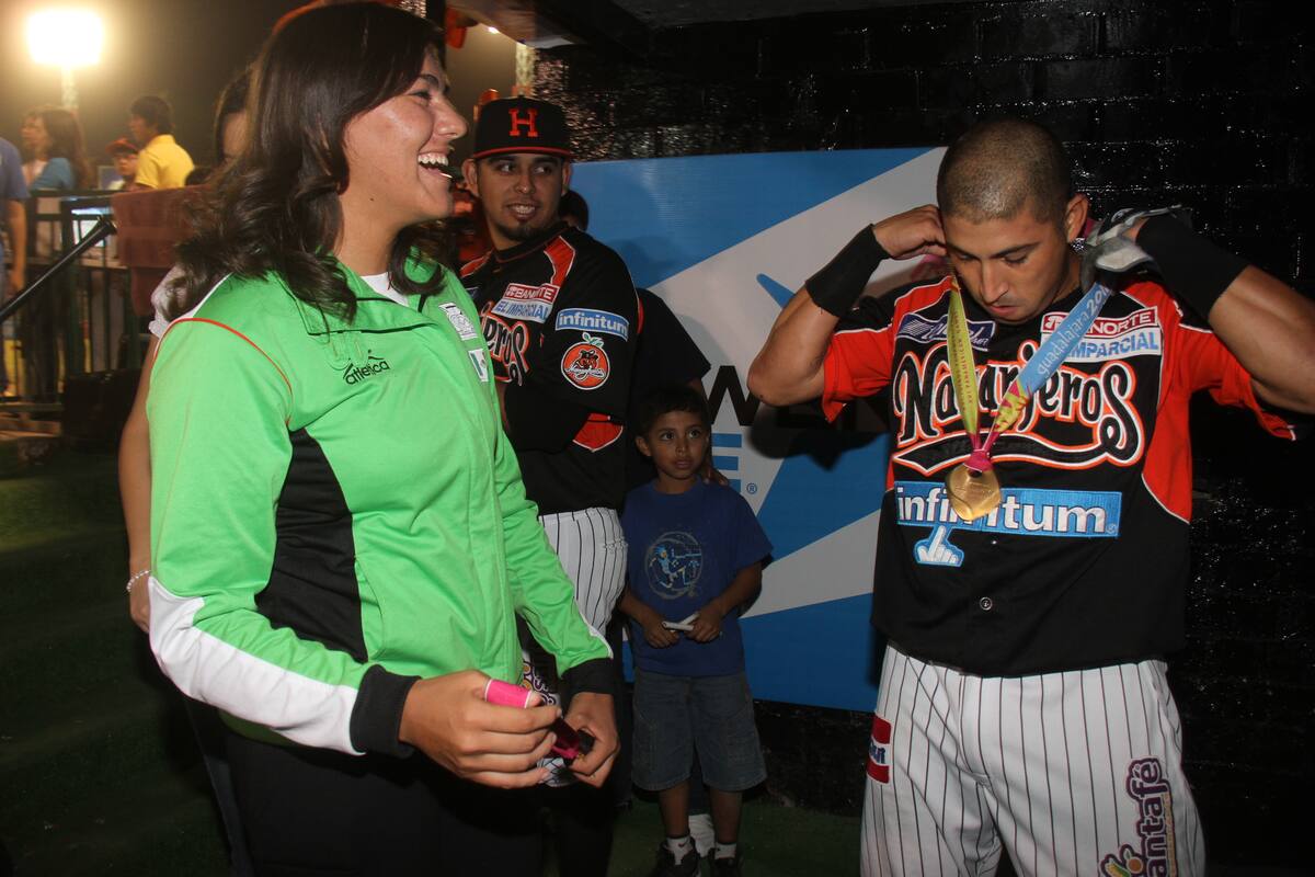 Carlos Gastélum se pone la medalla de oro de Alejandra Valencia. (2011) | Foto: Luis Gutiérrez.