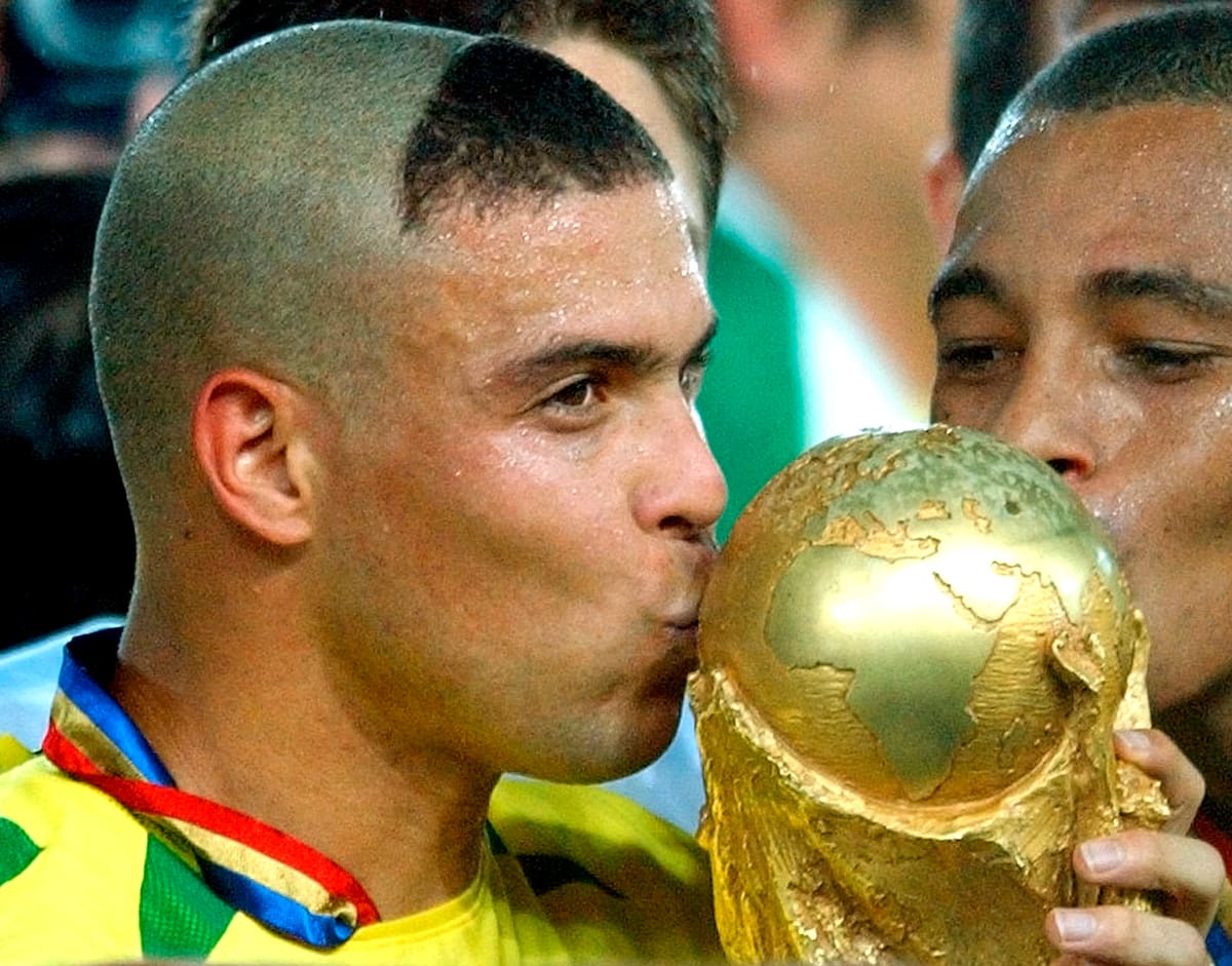 Los brasileños Ronaldo, a la izquierda, y Kleberson besan el trofeo después de que Brasil derrotara 2-0 a Alemania en la final de la Copa Mundial de 2002, disputada en el Estadio de Yokohama, Japón, el domingo 30 de junio de 2002. (AP Photo/Dusan Vranic)
