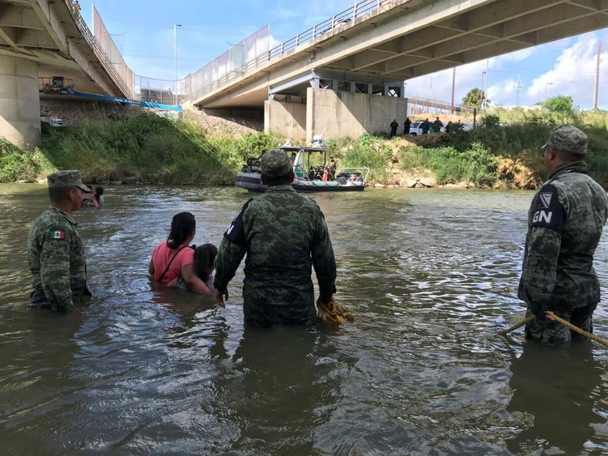 Fotografía de archivo. MATAMOROS (MÉXICO), 23/07/2019.- Miembros de la Guardia Nacional persuaden a una familia de migrantes de origen guatemalteco para que no crucen el caudal del Río Bravo este martes, en el punto fronterizo del Puente Nuevo, en Matamoros, estado de Tamaulipas (México). La promesa de la Patrulla Fronteriza de recibirlos para saber de su petición de asilo, logró que la familia, compuesta por dos infantes, saliera del río y cruzara sobre el puente donde ya los esperaba un grupo del departamento migratorio estadounidense para ingresarlos de forma segura a territorio norteamericano. Es una vista más de las que se están dando con continuidad y casi a diario en los afluentes del río Bravo, mudo testigo que arrastra a diario historias de sueños y vidas, a pesar de los riegos que representa. | Crédito: EFE/ Marco Rodríguez