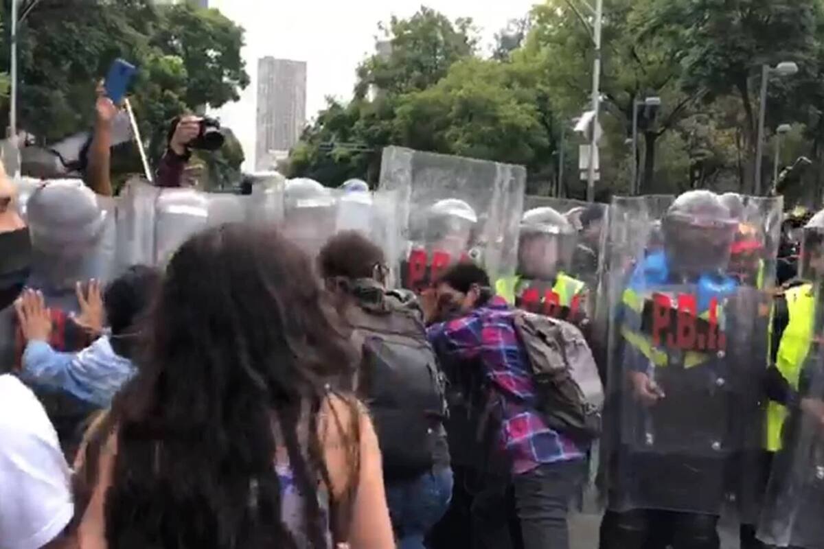Se enfrentan encapuchados y policías en marcha por Ayotzinapa; hay dos heridos