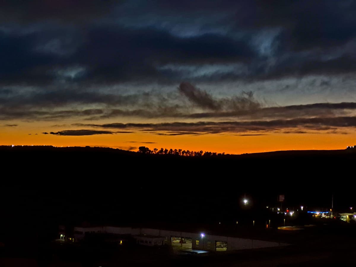 Remanentes con nubes densas en tonos grises plomizos se desplazaron hacia la costa del Pacífico, mientras una franja de luz en matices naranjas proyectó calidez visual. Foto: Sergio Ortiz