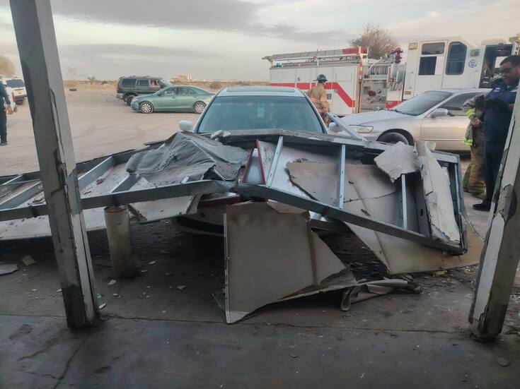 Colapsa anuncio sobre vehículo por fuertes vientos