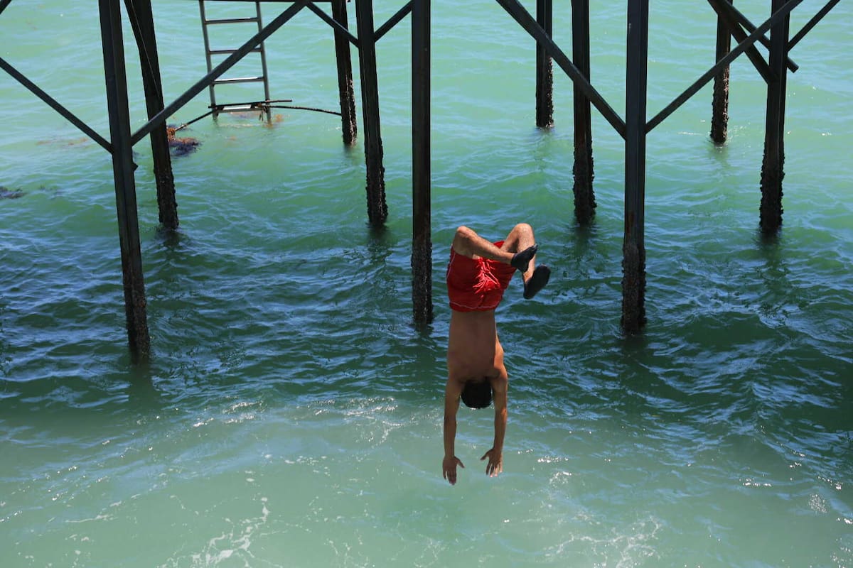 Un joven se lanza desde el muelle en Bahía de Kino, Sonora; esta actividad está prohibida y aplican multas por ello. | Julio A. Clark