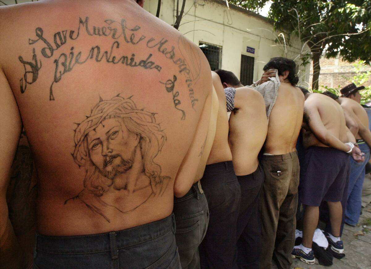 ** FILE ** Twenty gang members are presented by the police in San Salvador, El Salvador, in this Sept. 17, 2004 file photo,  as part of the new "Super Hard Hand"  operative to crack down on gang violence.  Police in El Salvador are establishing better contacts with their counterparts in California to gain leverage against gangs involved in smuggling, extortion and other crimes in both nations, officials said. The national police chief of El Salvador, Ricardo Menesses Orellana, is meeting this week with law enforcement officials in Southern California to arrange a new system to share information about notorious multinational street gangs such as the Mara Salvatrucha and the Mara 18. (AP Photo/Luis Romero)