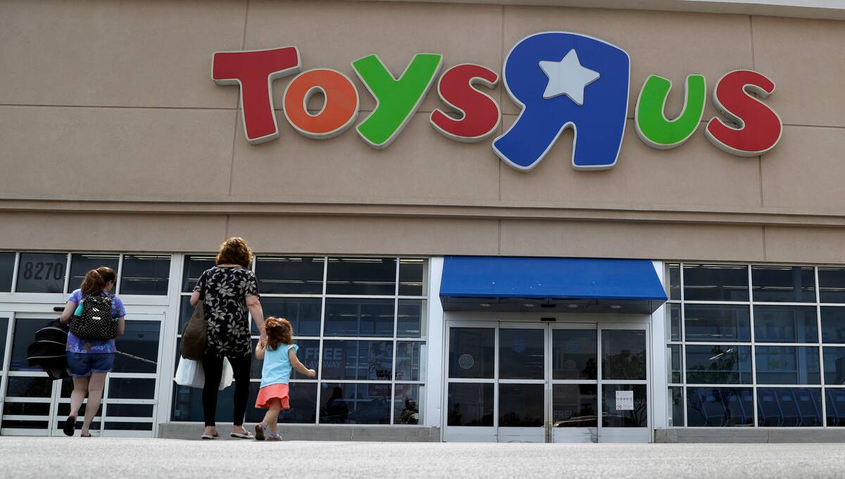 FILE - In this Sept. 19, 2017, file photo, shoppers walk into a Toys R Us store, in San Antonio. Toys R Us says it will be closing some U.S. stores and converting others to cobranded locations as it continues to deal with its financial restructuring following its bankruptcy filing. (AP Photo/Eric Gay, File)