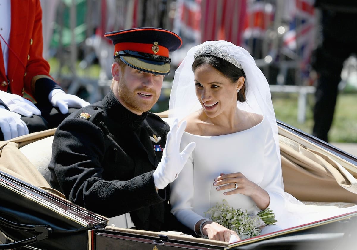 Meghan Markle reacts as she rides in a carriage with her husband Britain's Prince Harry after their wedding ceremony at St. George's Chapel in Windsor Castle in Windsor, near London, England, Saturday, May 19, 2018. (Jeff J Mitchell/pool photo via AP)