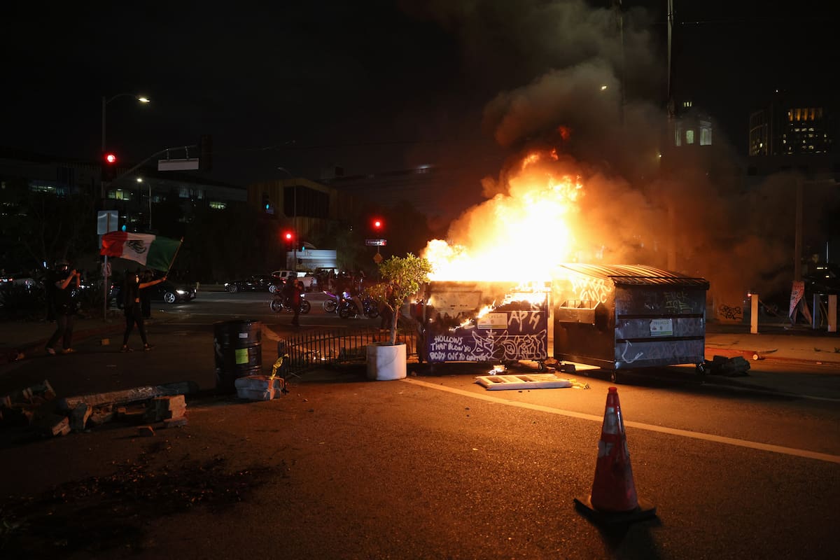 Un incendio en un basurero se inicia durante las protestas provocadas por las redadas de inmigración en Los Ángeles, California, EE.UU. EFE/ALLISON DINNER