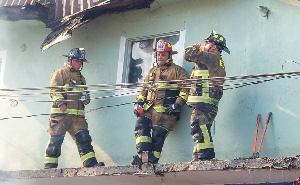 Personal de Bomberos se rehidrata luego de su labor sofocando el incendio.