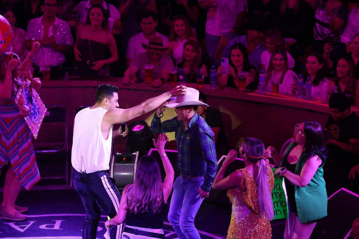 Carlos Rivera sostiene el sombrero de un joven que subió al redondel a bailar. |Gerardo D. Gonsález