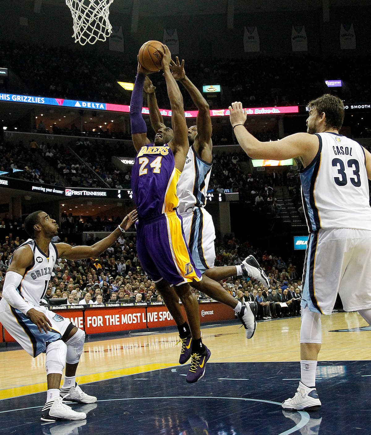 Los Angeles Lakers guard Kobe Bryant (24) is fouled by Memphis Grizzlies guard Tony Allen, back, while heading to the basket between Grizzlies' Marc Gasol (33) and Mike Conley (11) in the first half of an NBA basketball game on Friday, Nov. 23, 2012, in Memphis, Tenn. (AP Photo/Lance Murphey)