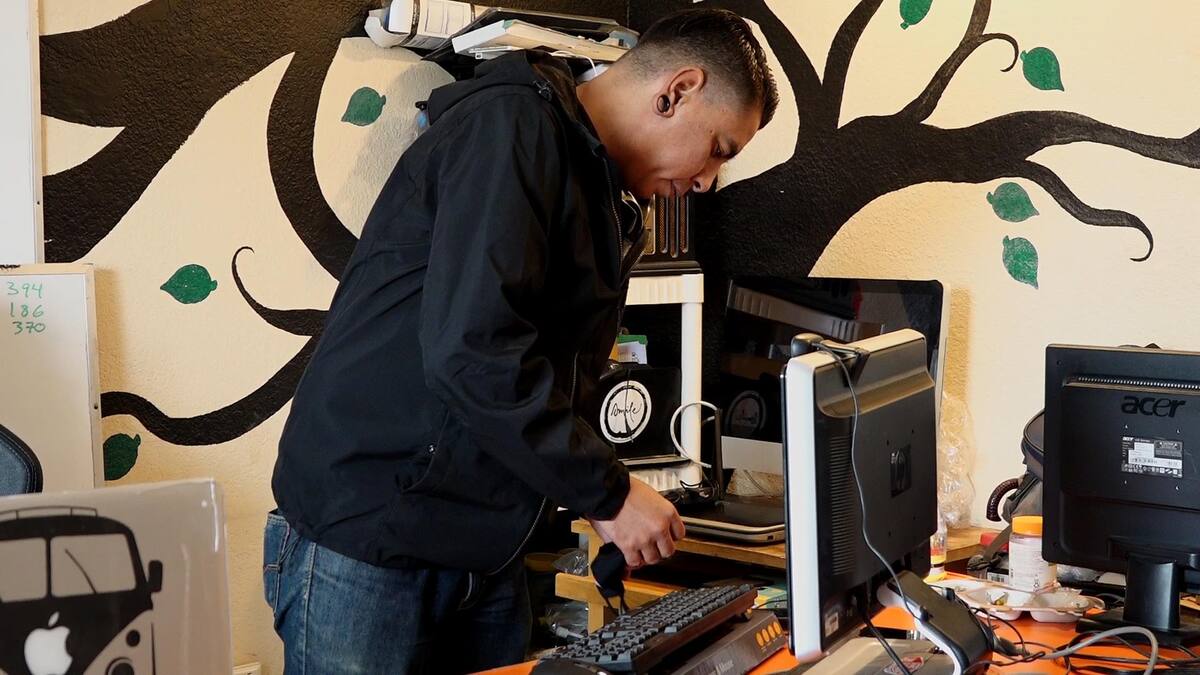 Edgar Cárdenas, arregla computadoras para entregarlas a sus estudiantes