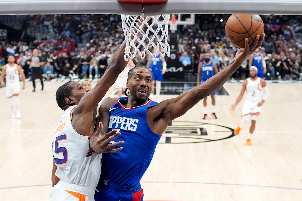 Kawhi Leonard (derecha) de los Clippers de Los Ángeles dispara al aro ante Kevin Durant de los Suns de Phoenix, el lunes 8 de enero de 2024. (AP Foto/Mark J. Terrill)