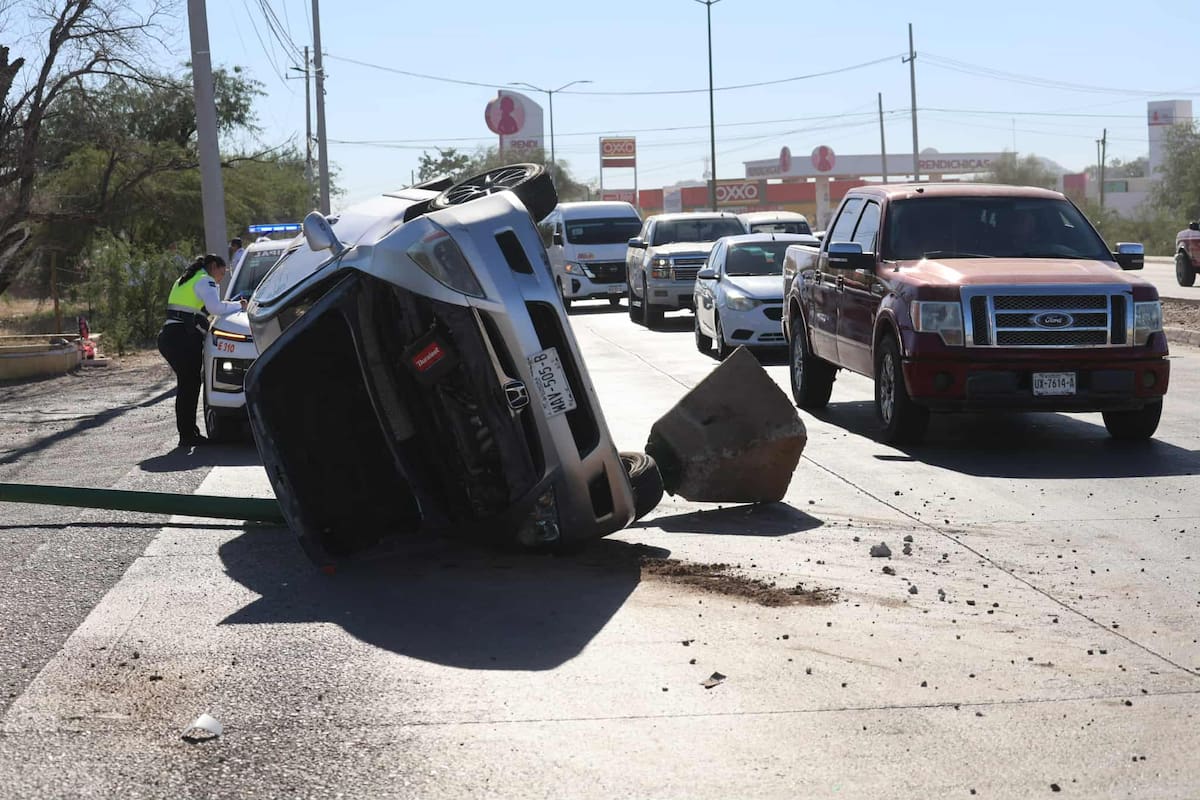 El automóvil volcado y el poste de alumbrado público.