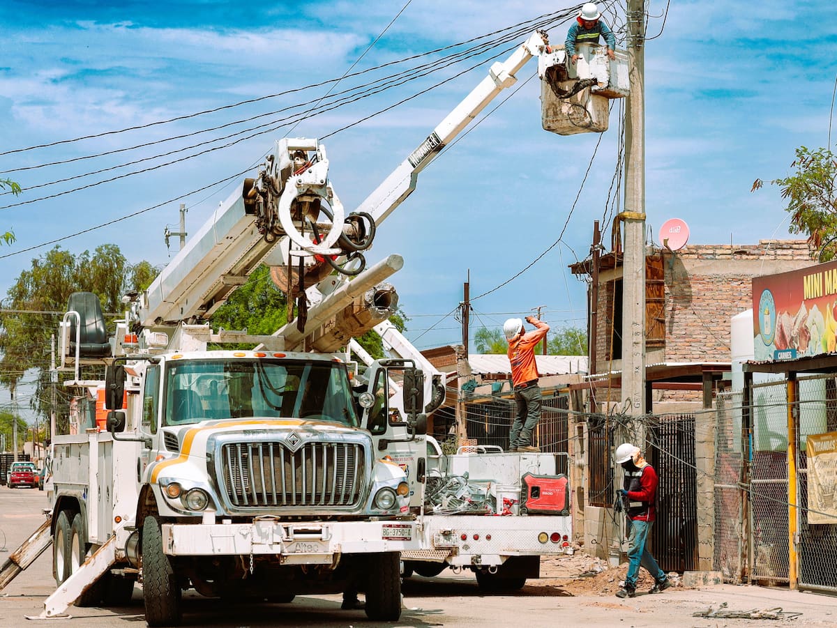 Personal de la CFE realiza la reposición de postes del servicio de distribución de energía eléctrica en la zona poniente de Mexicali, durante los horarios de mayor calor en la ciudad. (FOTO: JUAN J. MORALES)