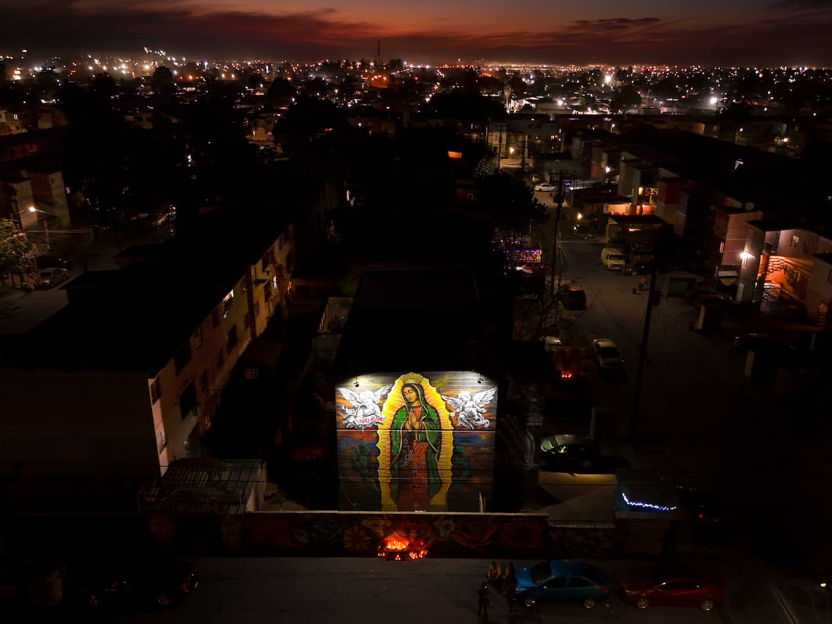 Con motivo del Día de la Virgen, los feligreses acudieron al mural en el fraccionamiento el Cóndor, para realizar sus ofrendas. Allí, encendieron veladoras y depositaron flores, manifestando su fe a través de oraciones de agradecimiento y súplica. (Foto: Juan J. Morales)