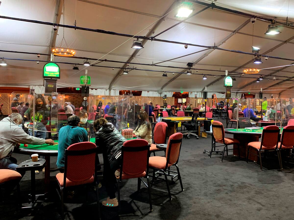 Varias personas juegan este jueves en el casino Artichoke Joe's de San Bruno, California (Estados Unidos), que se las ha apañado para abrir al aire libre y con fuertes medidas sanitarias, pero que sigue sin poder ofrecer su juego más popular: el póker. EFE/ Marc Arcas