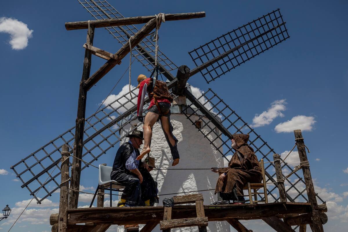 Fotografía del viernes 21 de junio de 2019 de un miembro de la “Hermandad del Santísimo Sacramento Pecados y Danzantes” colgado en la horca durante una procesión como parte de las celebraciones de Corpus Christi en Camuñas, España. (AP Foto/Bernat Armangue)