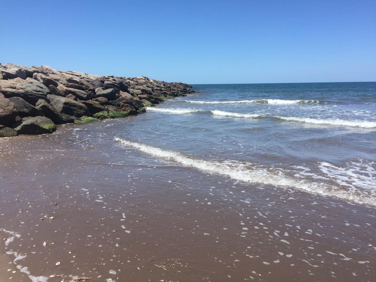 En esta escollera chocan las suaves olas del mar.
