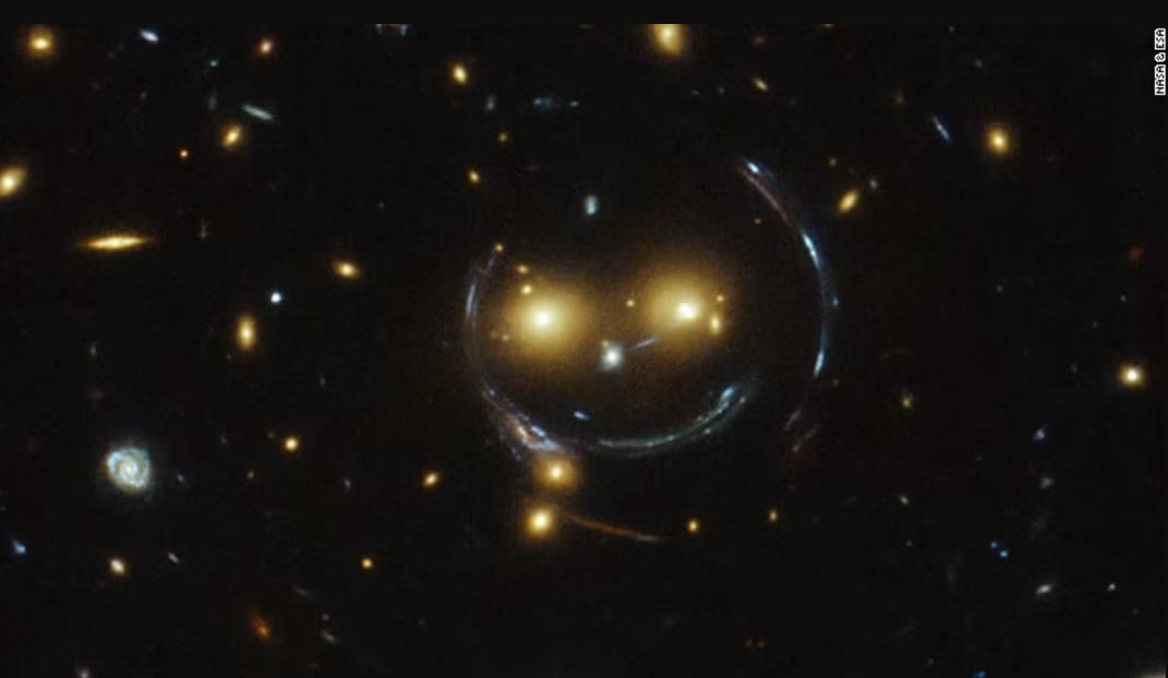 La imagen de un cúmulo de galaxias que parece formar un rostro sonriente ilustra el misterio del universo y los límites de la comprensión humana, una de las ideas centrales del terror cósmico. Foto: NASA
