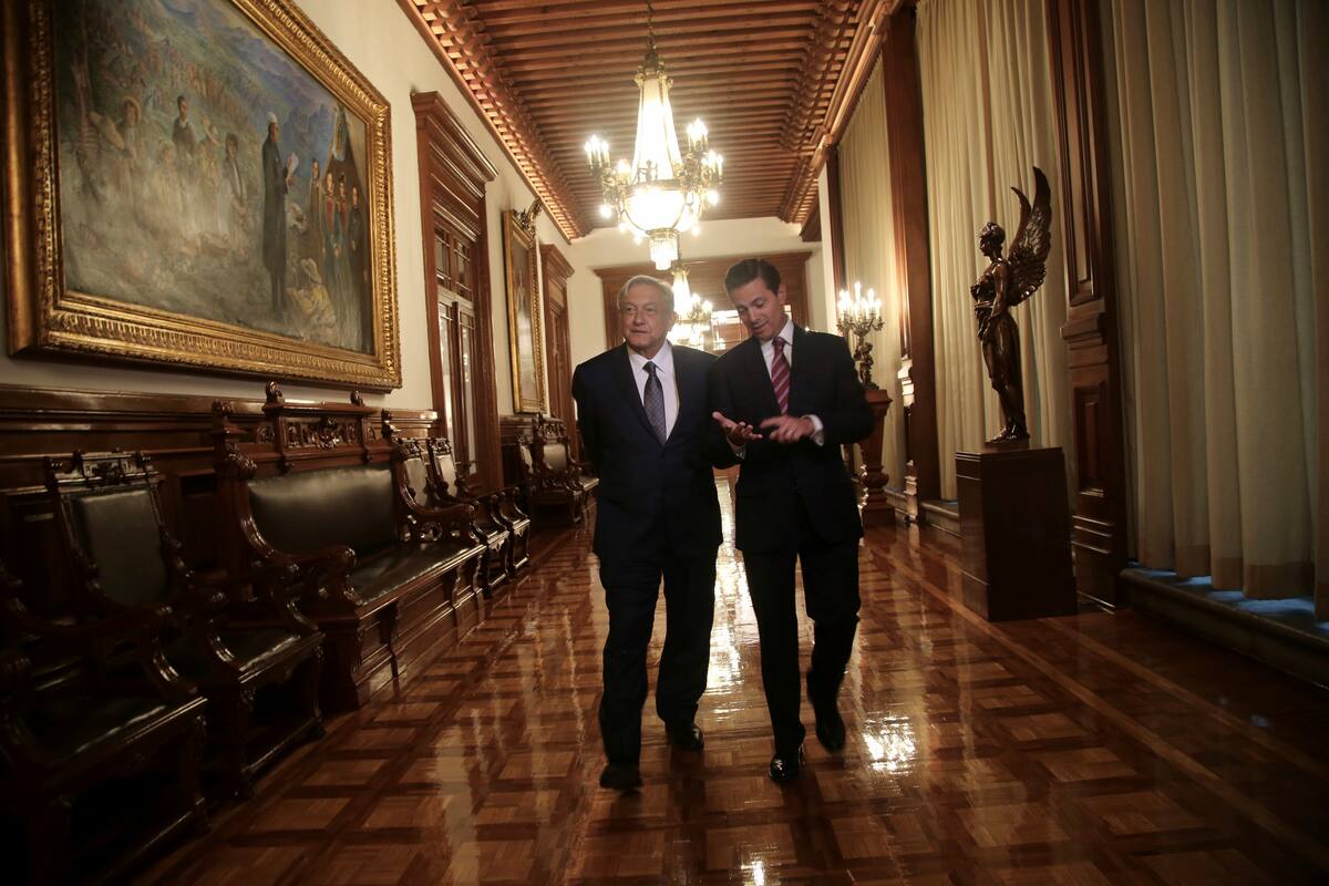 In this photo released by the press office of Mexico's President-elect Andres Manuel Lopez Obrador, Mexican President Enrique Pena Nieto, right, walks with Lopez Obrador inside the National Palace in Mexico City, Thursday, Aug. 9, 2018. Lopez Obrador will take office Dec. 1. (Press Office of Andres Manuel Lopez Obrador via AP)