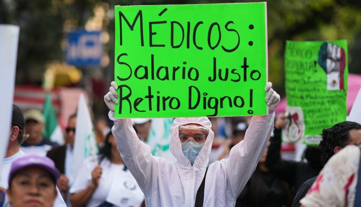 Un trabajador de la salud sostiene un letrero de protesta con la consigna "Médicos: Salario Justo, Retiro Digno" durante las manifestaciones del personal del IMSS por condiciones laborales e insumos. | Archivo GH