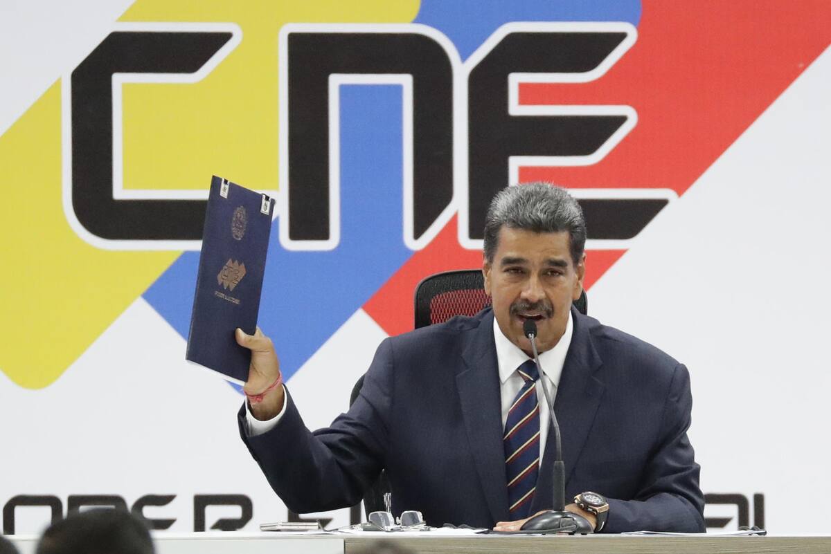 El presidente de Venezuela, Nicolás Maduro, sostiene el acta de juramentación del presidente electo entregada por el presidente de Consejo Nacional Electoral (CNE), Elvis Amoroso (no en la foto), este lunes, en Caracas, Venezuela. | Crédito: EFE/ Ronald Peña R.