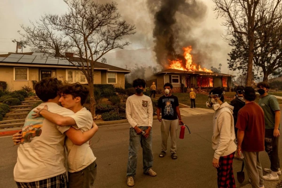 Residentes se abrazan afuera de una propiedad en llamas mientras el incendio Eaton arrasaba Altadena, California, el 8 de enero de 2025. | Crédito: AP/Ethan Swope, Archivo