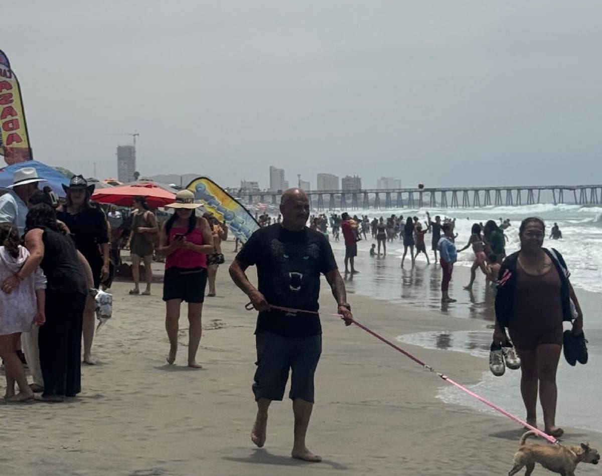 Cientos de familias acudieron este sábado a la playa de Rosarito para refrescarse del calor, mientras salvavidas mantuvieron la bandera roja por el fuerte oleaje. Foto: Carmen Gutiérrez.