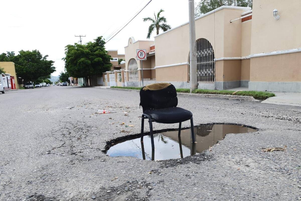 Avisan con una silla: "Aquí hay un bache"