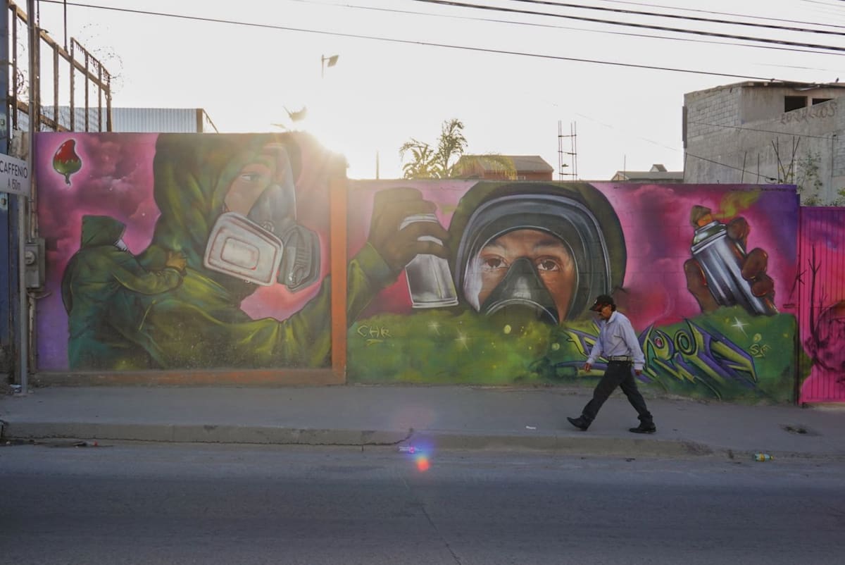 El artista Eduardo Gómez, conocido como Serie y Chile Rage, pinta una obra que explora identidad y cultura fronteriza a través del graffiti. Foto: Border Zoom