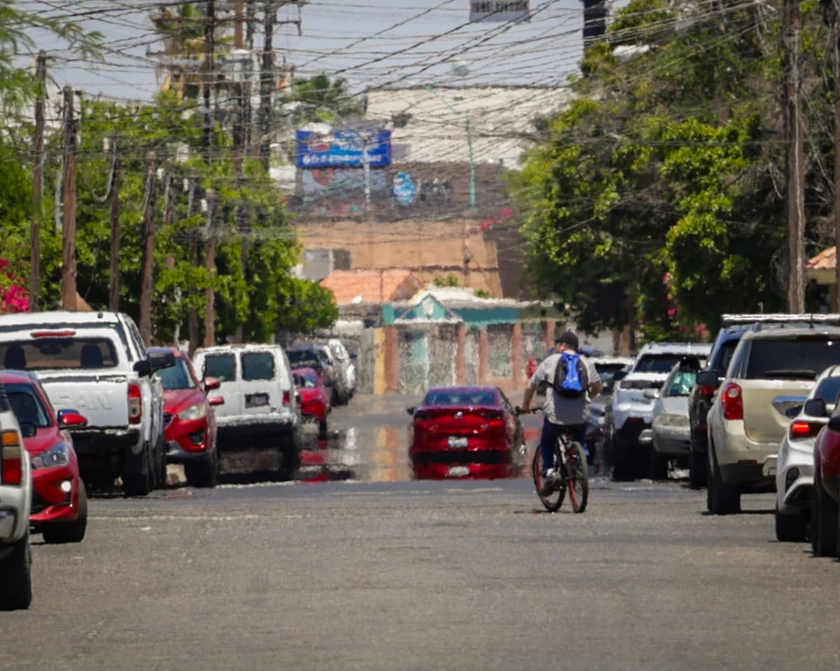 Un espejismo provocado por las altas temperaturas crea la ilusión de agua sobre el pavimento en una calle de Mexicali, donde el intenso calor modifica la refracción de la luz. (Javier Gallegos)