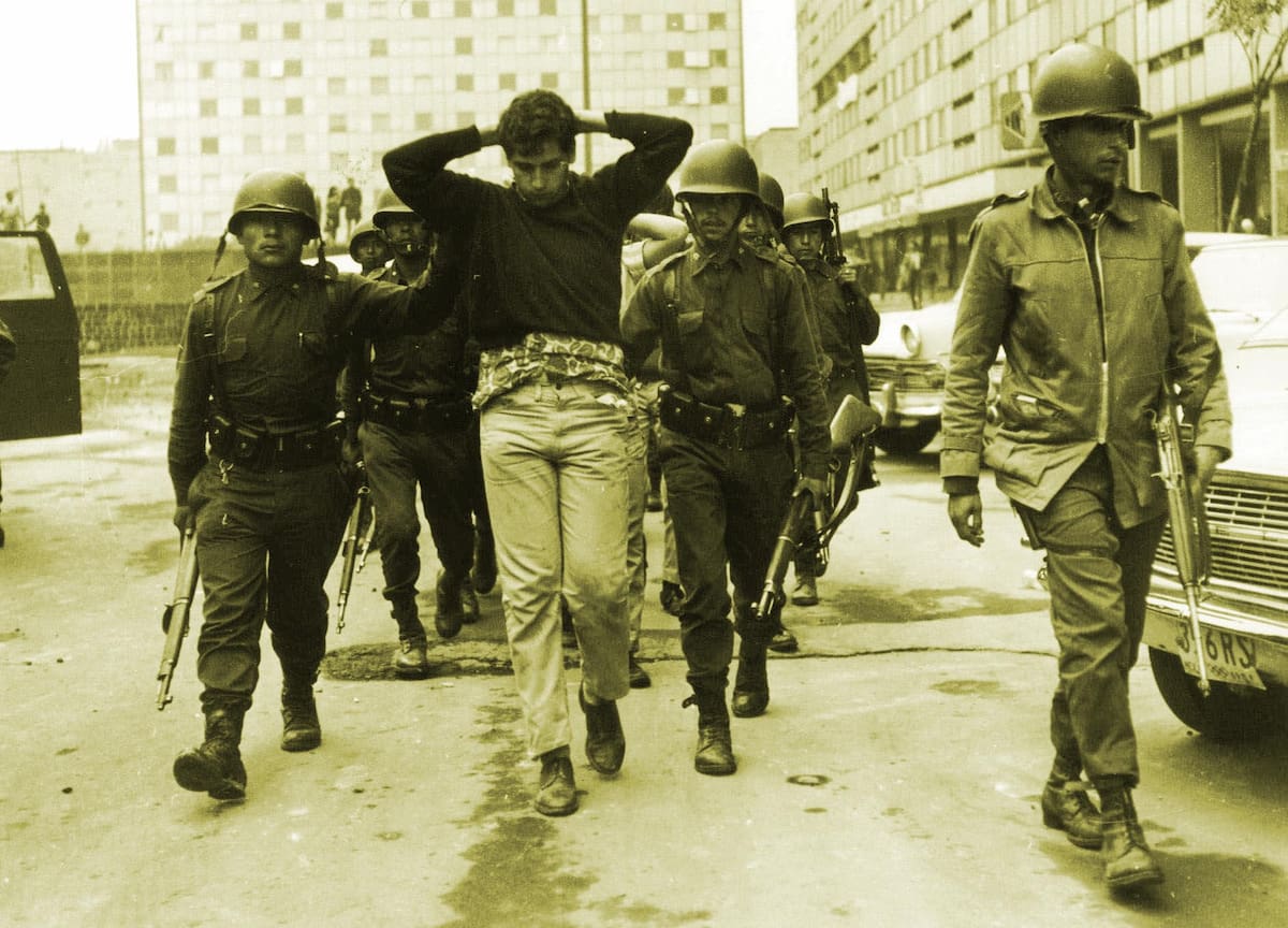 Tropas del ejército mexicano escoltan a manifestantes arrestados en la Ciudad de México, el 3 de octubre de 1968, tras una noche de violencia entre el ejército y los manifestantes, en su mayoría estudiantes. Los enfrentamientos, que pasaron a ser conocidos como la "Masacre de Tlatelolco" por la plaza del centro de la ciudad donde ocurrieron, dejaron hasta 300 muertos. Sin embargo, la mayoría de los medios de comunicación mexicanos publicaron informes del ejército que indicaban que 27 personas habían fallecido. (Foto AP)
