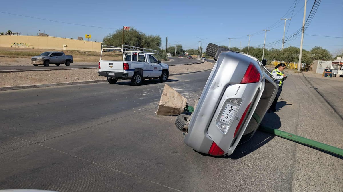 El automóvil volcado y el poste de alumbrado público.