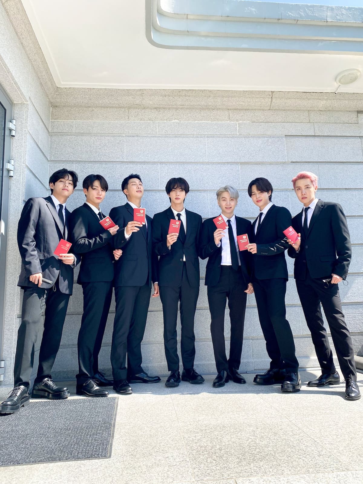 BTS posando con sus pasaportes diplomáticos después de ser nombrados enviados especiales presidenciales por el entonces presidente de Corea del Sur, Moon Jae-in, en septiembre de 2021. | Foto: Especial GH.