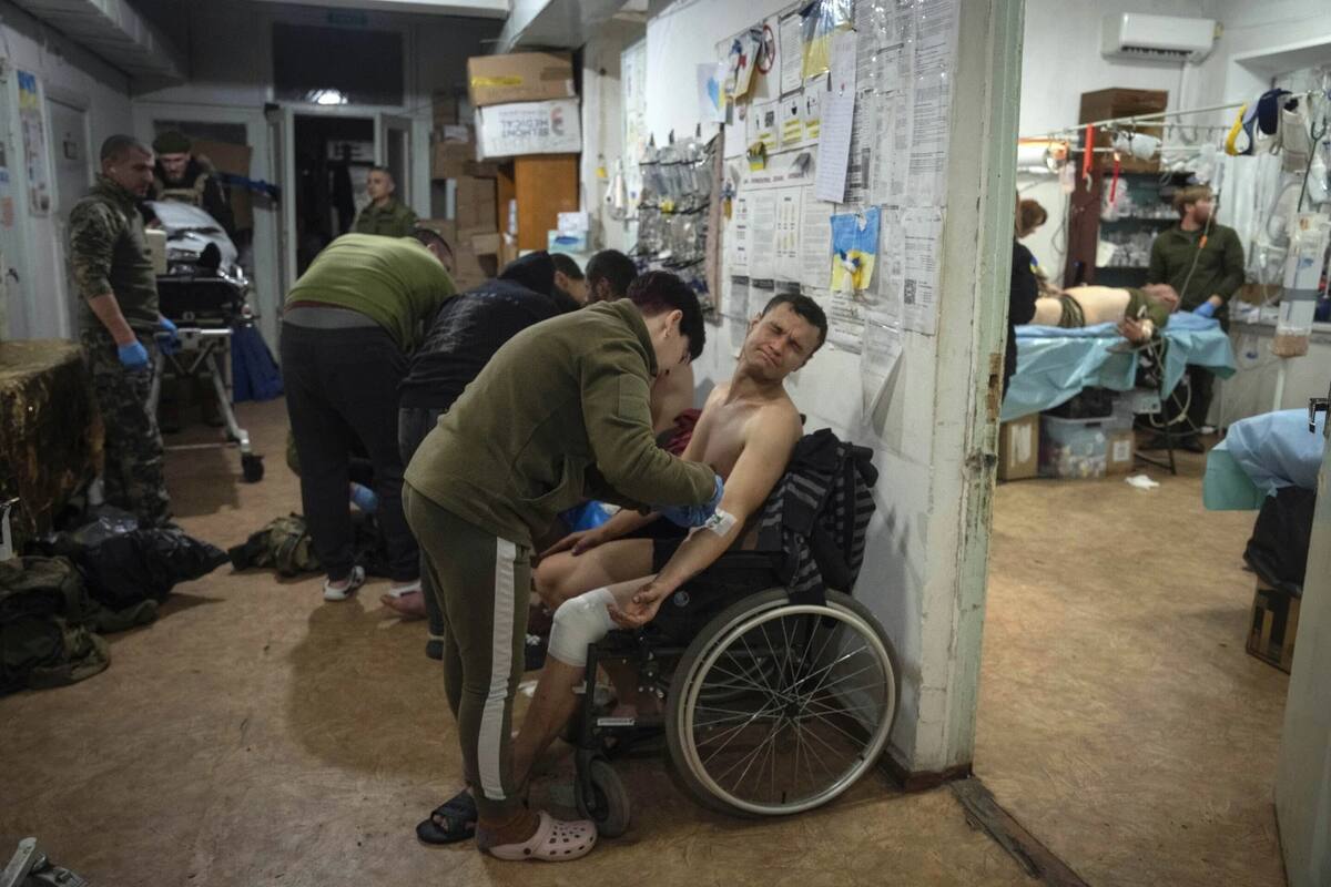 ARCHIVO – Médicos militares brindan primeros auxilios a soldados ucranianos heridos cerca de Bakhmut, Ucrania, el 25 de enero de 2024. | Crédito: AP/Efrem Lukatsky, Archivo