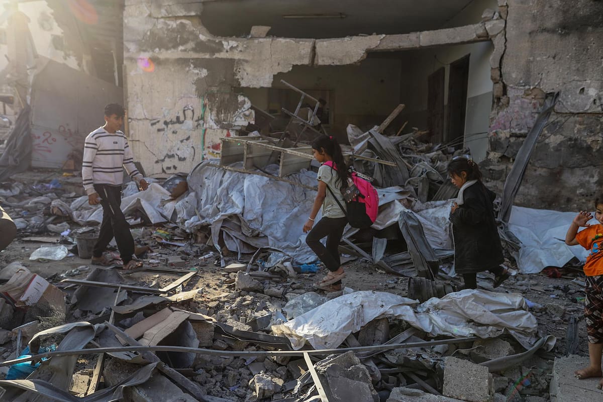 Fotografía de archivo, tomada el 22/05/2025, que muestra a palestinos caminando sobre un edificio destruido en Gaza por ataques israelíes. | Crédito: EFE/EPA/MOHAMMED SABER