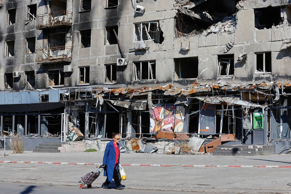 Una residente local pasa por delante de un bloque de apartamentos dañado en el transcurso del conflicto entre Rusia y Ucrania en Mariúpol, Ucrania. 25 de septiembre, 2022. REUTERS/Alexander Ermochenko