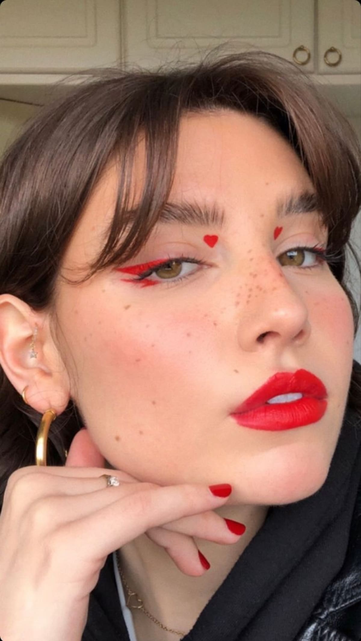 Toques de amor: Los mini corazones gráficos con delineador son el detalle viral que transforma un look básico en uno divertido y temático.