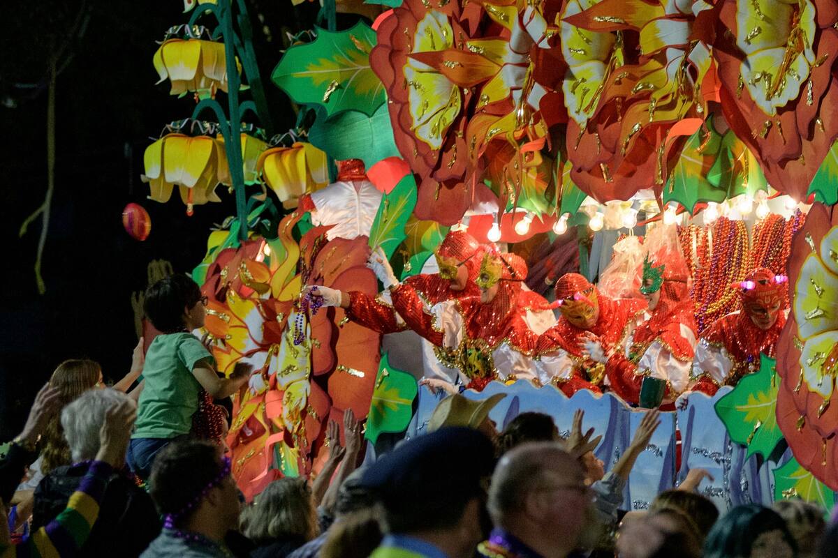 ARCHIVO - En esta foto del 24 de febrero de 2020, participantes disfrazados en una carroza con tema de "Beastly Kingdoms" arrojan collares a los juerguistas en la avenida Napoleón durante las celebraciones de Mardi Gras en Nueva Orleans. (AP Foto/Matthew Hinton, Archivo)
