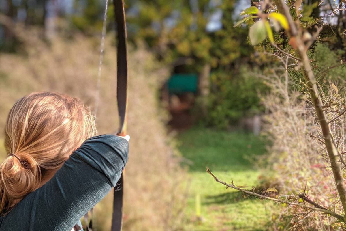 Madre con su bebé a la espalda caza con arco