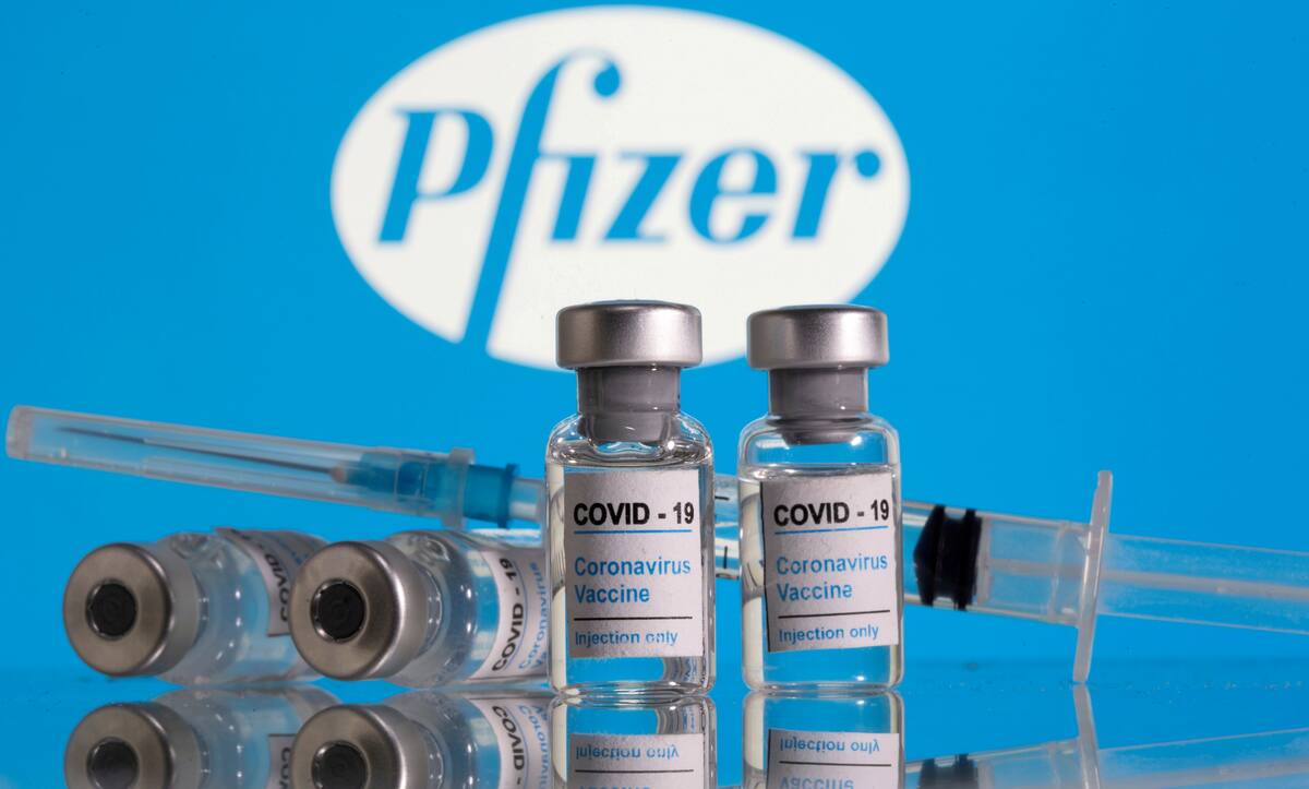 IMAGEN DE ARCHIVO. Frascos con la etiqueta de "Vacuna COVID-19 Coronavirus" y una jeringa se ven frente al logo de Pfizer en esta ilustración tomada en febrero 9, 2021. REUTERS/Dado Ruvic