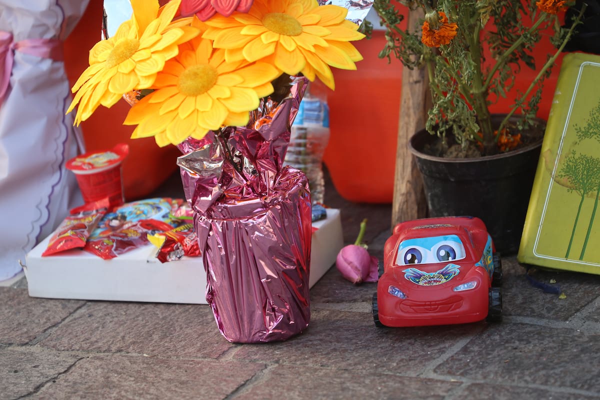 Flores, veladoras y juguetes llegan a colocar en el improvisado altar. FOTO: JULIÁN ORTEGA