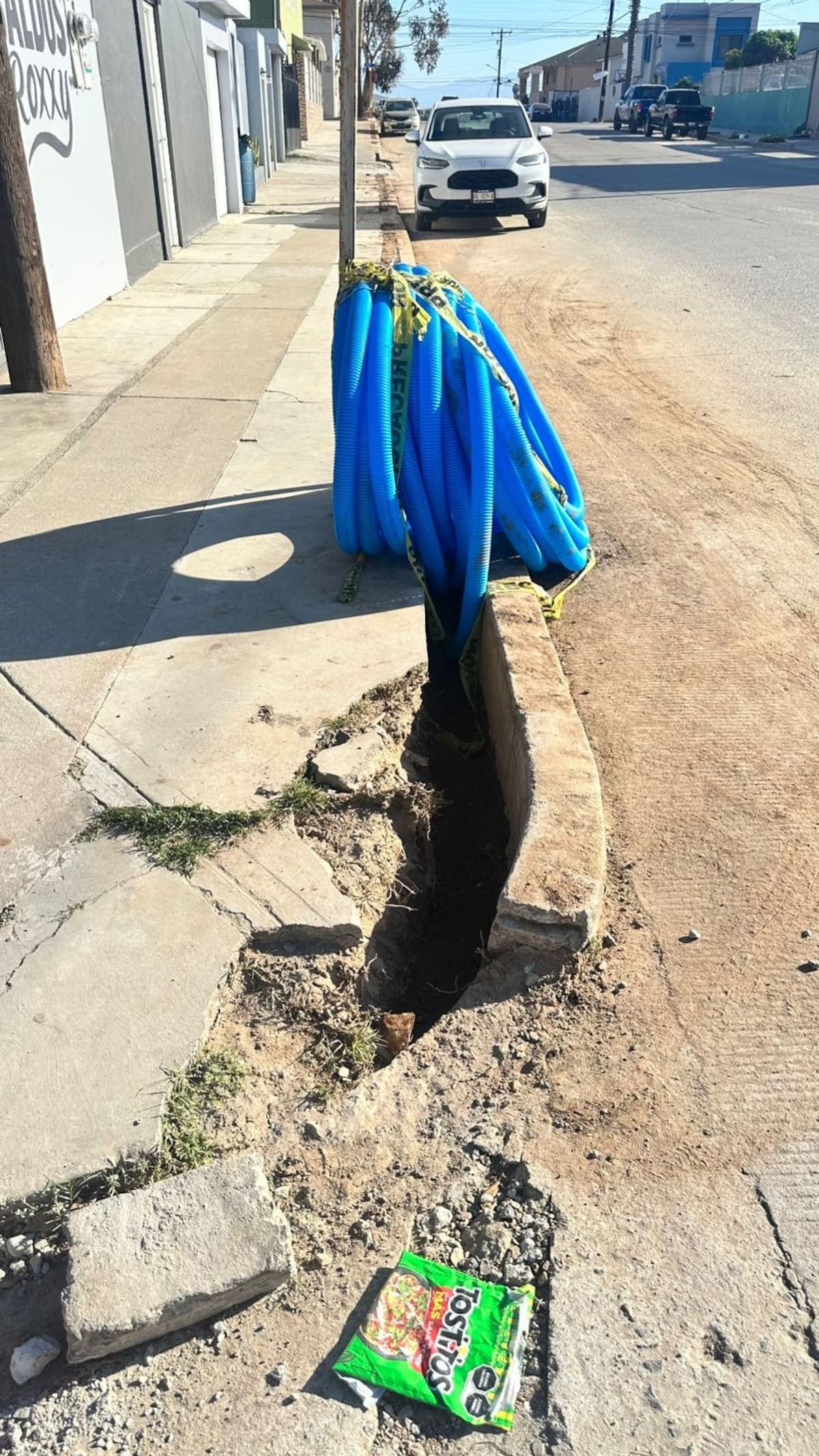 Residentes de la colonia Piedras Negras en Ensenada denunciaron daños en la avenida 5 de Febrero luego de que una empresa de televisión por cable realizara trabajos para instalar material subterráneo y abriera banquetas. Foto: Cortesía