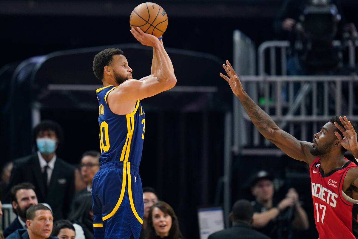 El base de los Warriors de Golden State Stephen Curry lanza un triple sobre el alero de los Rockets de Houston Tari Eason. (AP Foto/Godofredo A. Vásquez)