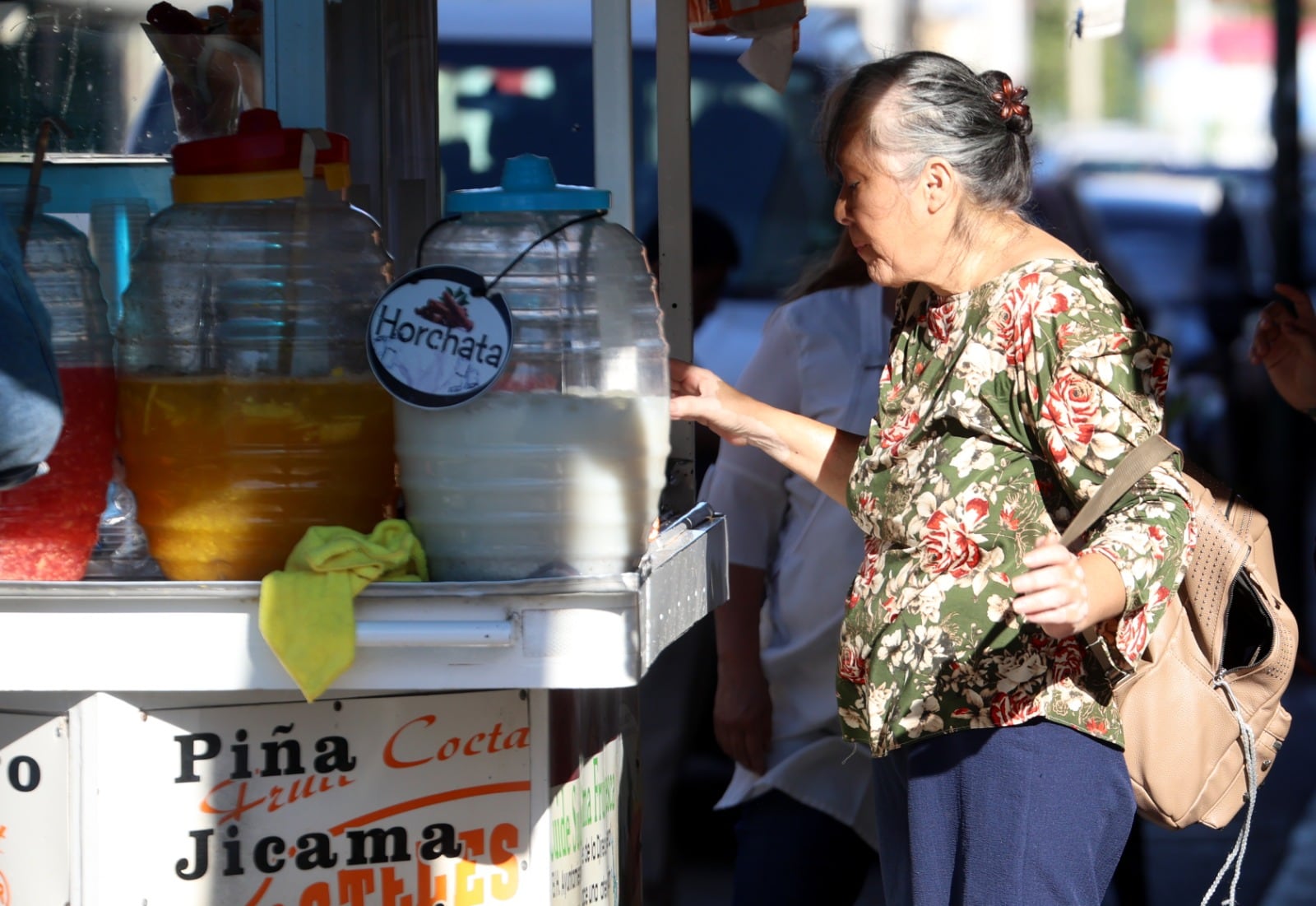 Una mujer se acerca a un puesto de aguas frescas para enfrentar el calor en Hermosillo, Sonora. | Julián Ortega