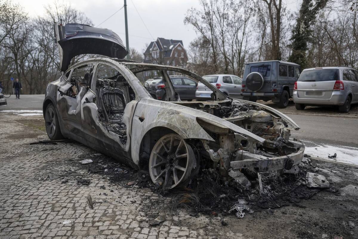 Un coche Tesla calcinado se encuentra en el distrito de Steglitz en Berlín, el viernes 14 de marzo de 2025, mientras se sospecha que cuatro Teslas fueron incendiados en Berlín la noche anterior. | Crédito: Christophe Gateau/dpa vía AP