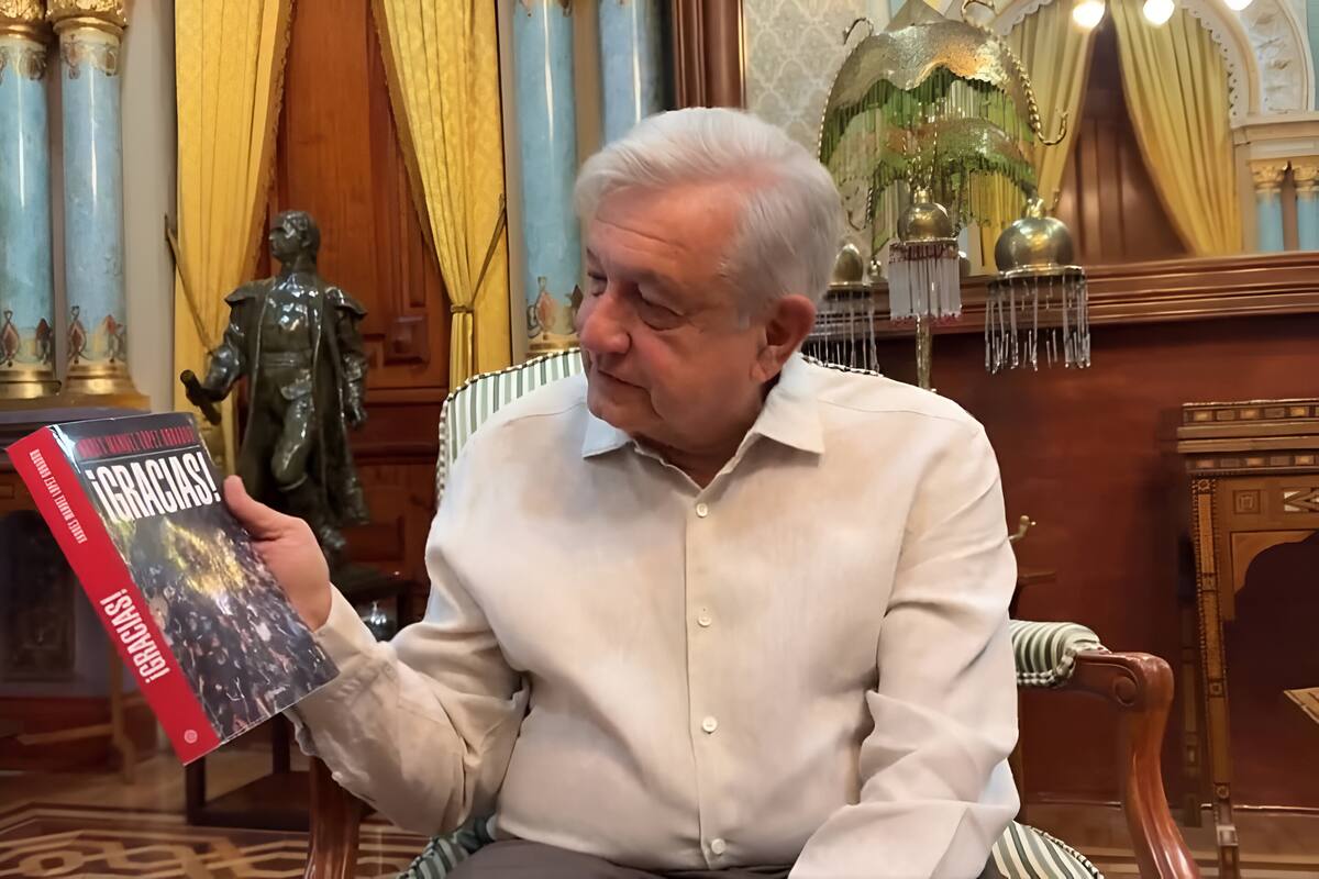 El presidente Andrés Manuel López Obrador sostiene su libro "!Gracias!". | Captura de video
