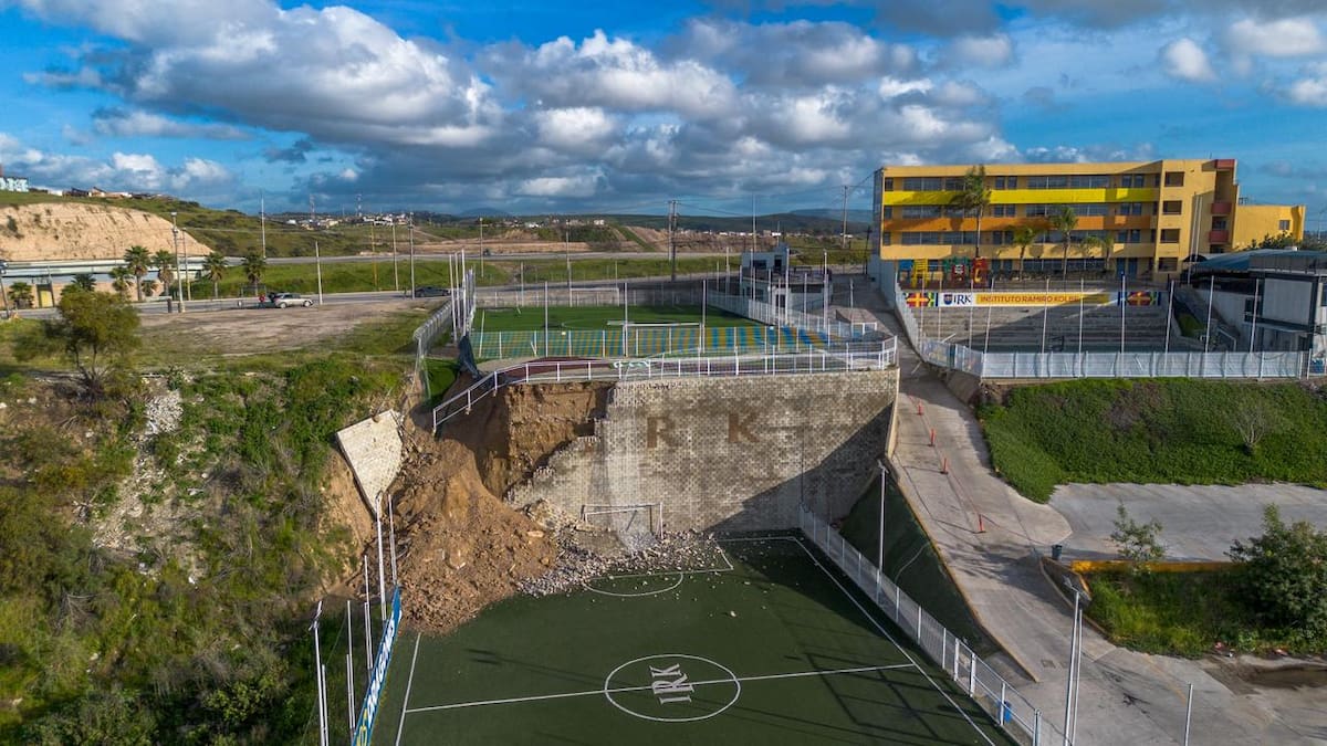 Un deslave de tierra provocado por las recientes lluvias ocasionó el colapso de una barda que dividía dos canchas deportivas del Instituto Kolbe, dejando un cúmulo de tierra, rocas y fragmentos de concreto. Foto: Border Zoom