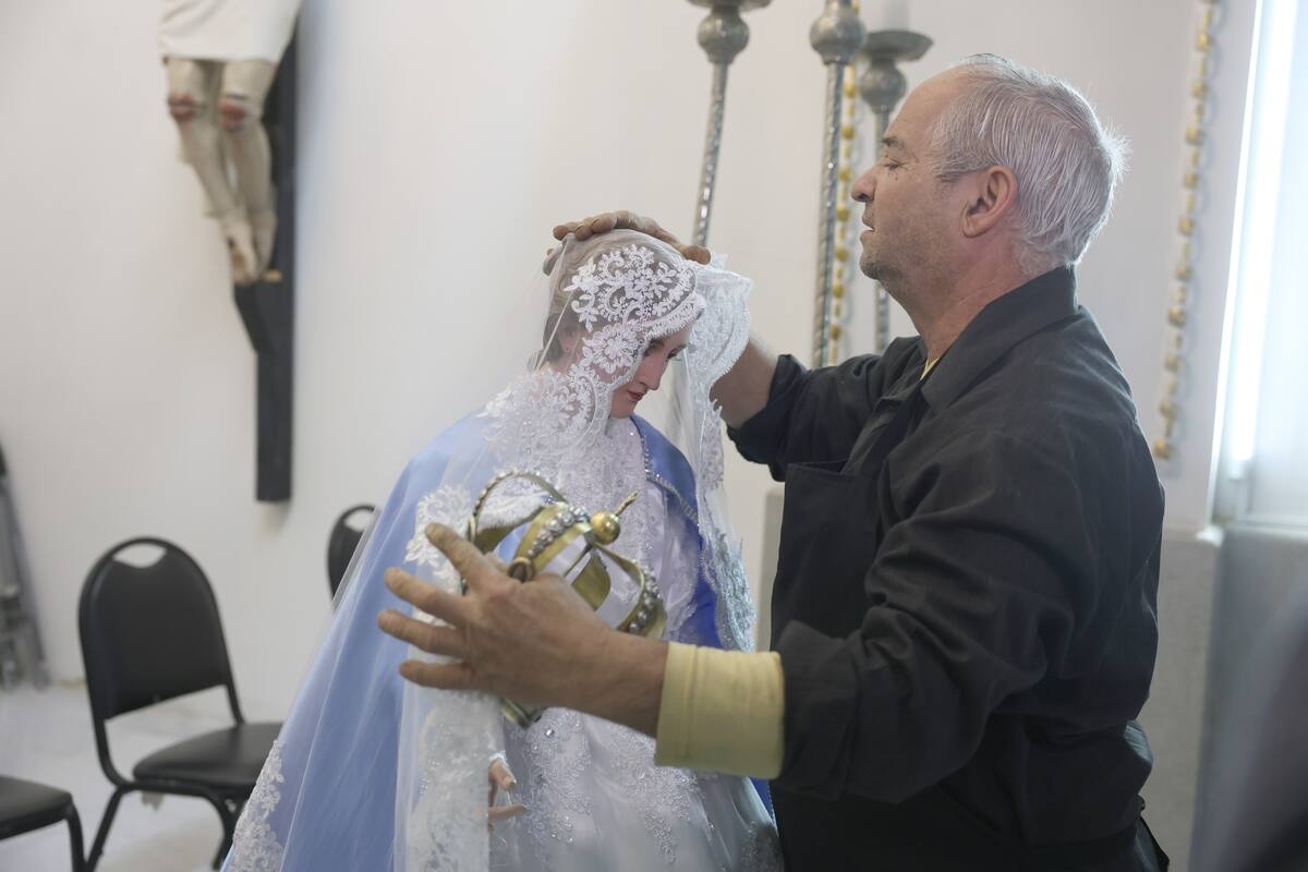 Con mucha delicadeza y respeto, los encargados visten a la Virgen. FOTO: TEODORO BORBÓN