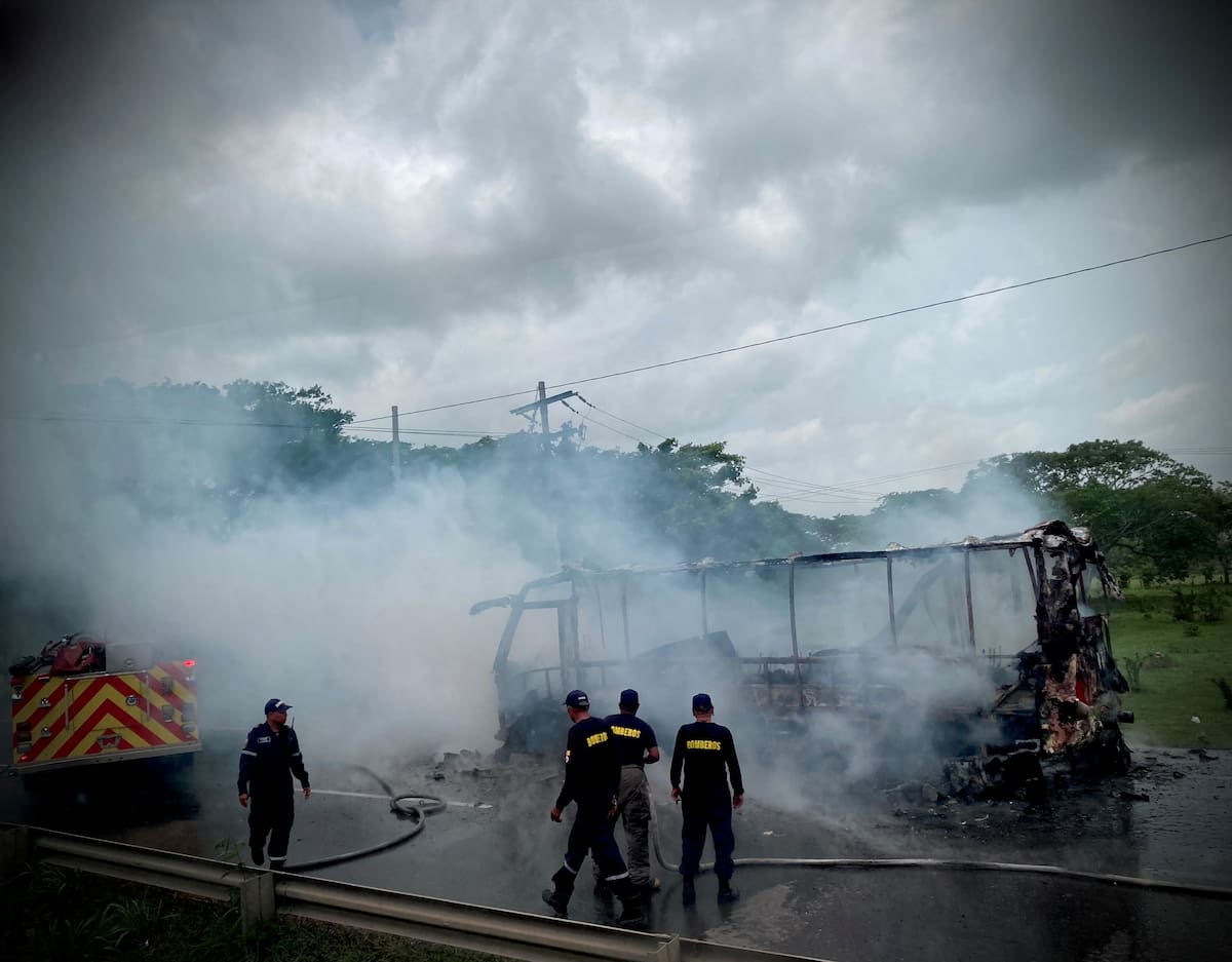 Bomberos observan los restos humeantes de un autobús incendiado por integrantes del Clan del Golfo en medio de un "paro armado". Colombia, 5 de mayo, 2022. Imagen tomada de redes sociales. Viviana Vargas, defensora de DDHH/Vía REUTERS